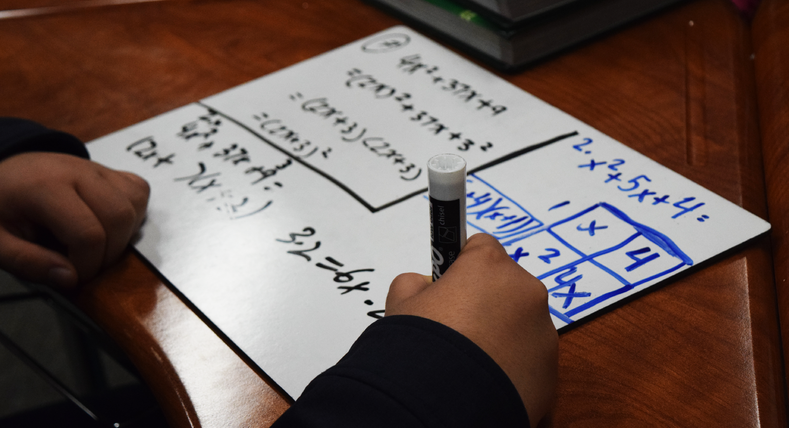 Student doing math on a small whiteboard